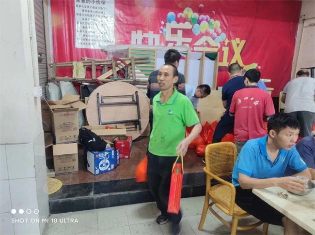 聚餐后同事們提著公司發放的月餅和柚子回家